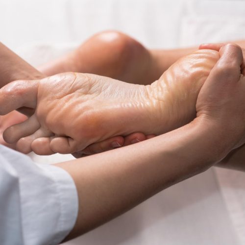 Masseur, der Fußmassage mit Öl im Spa-Salon