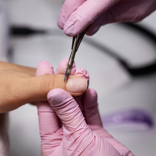 Nagelkunstfachmann, der an Kundennägeln arbeitet